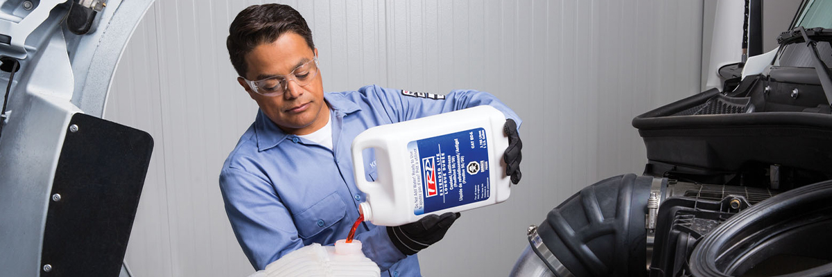 Kenworth mechanic pouring antifreeze into reservoir